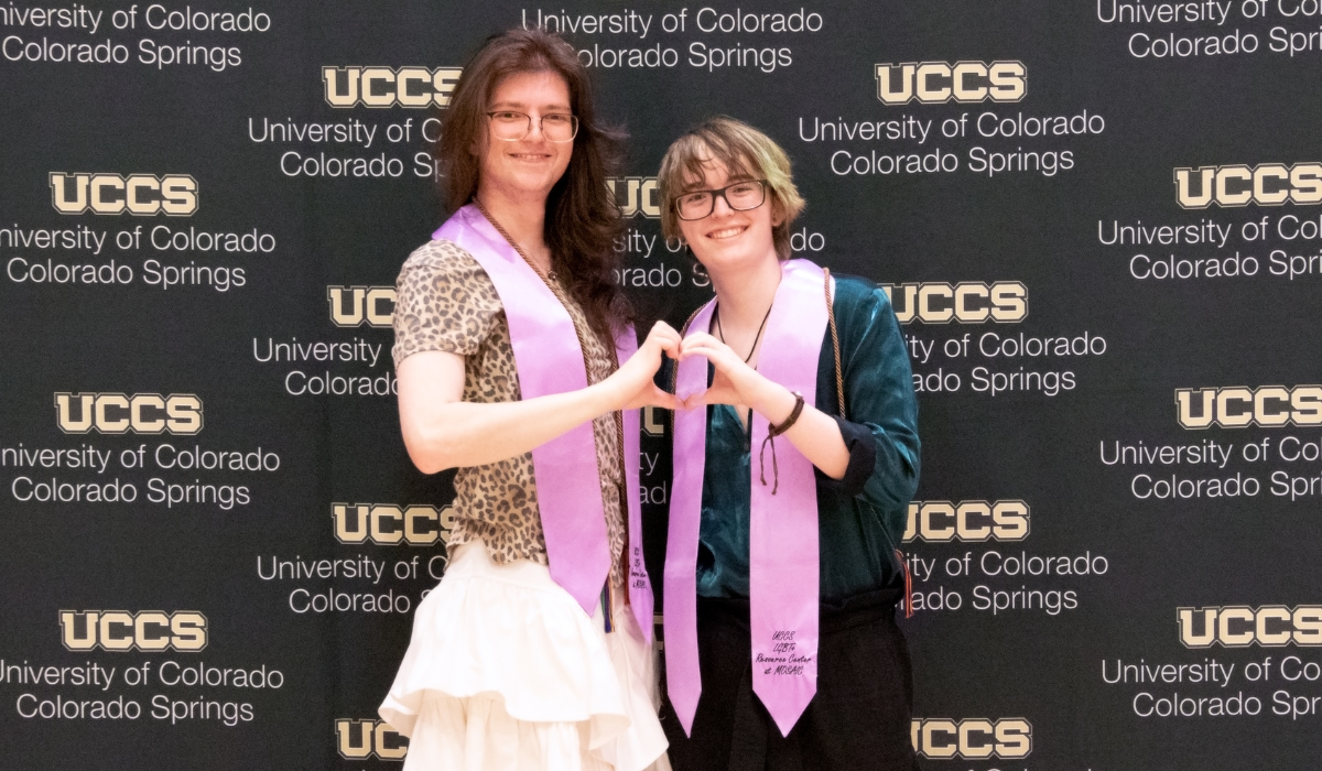 Photo of two graduates wearing lavender stoles